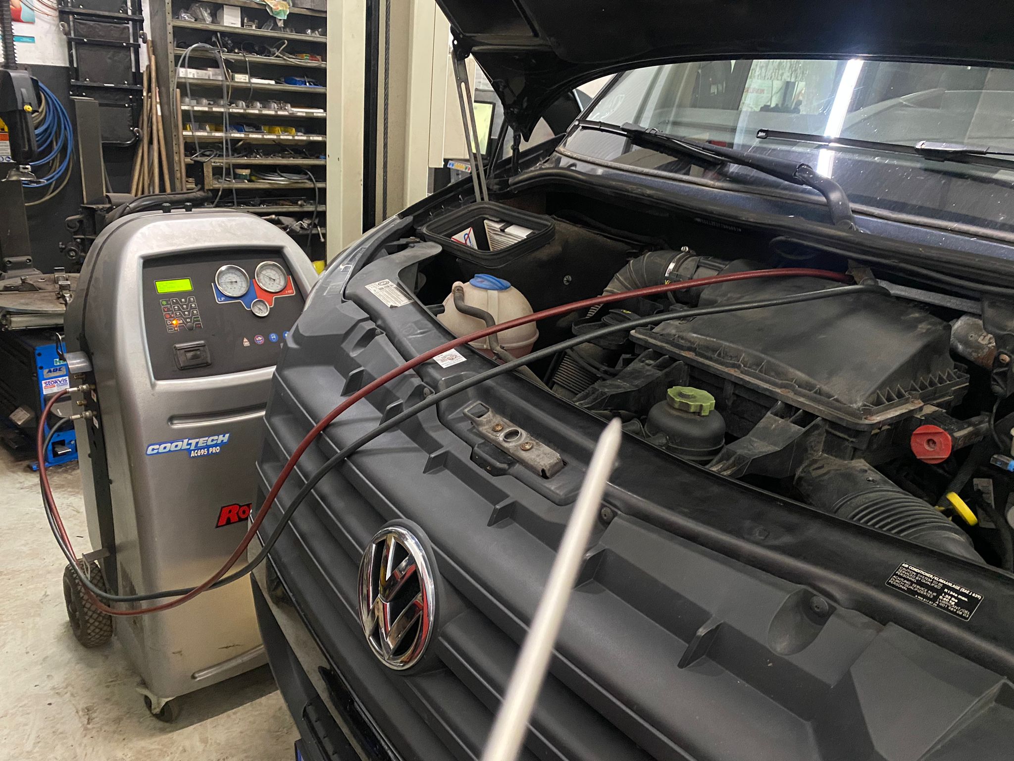 Airco-servicemachine naast een geopende motorruimte van een VW bus